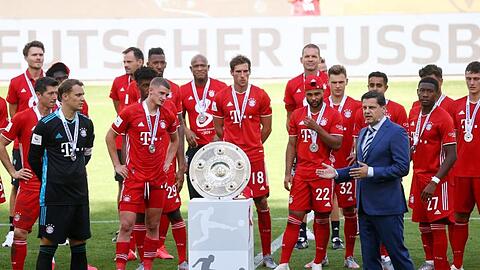 Christian Seifert überreicht nach einer denkwürdigen Saison den Bayern-Profis die Meisterschale.