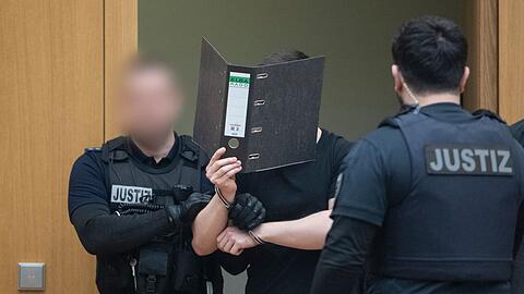 Zwei der M&auml;nner verdeckten beim Betreten des Gerichtssaals ihr Gesicht.