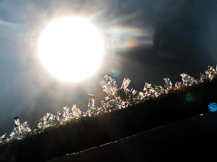 Eiskristalle glitzern im Licht der aufgehenden Sonne.