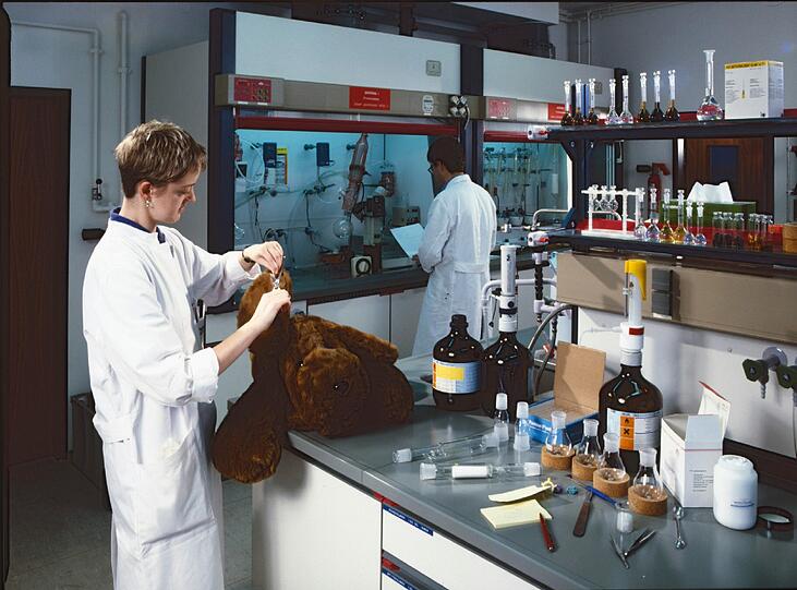 1955: Eine Tüv-Prüferin untersucht im Labor einen Teddybär.