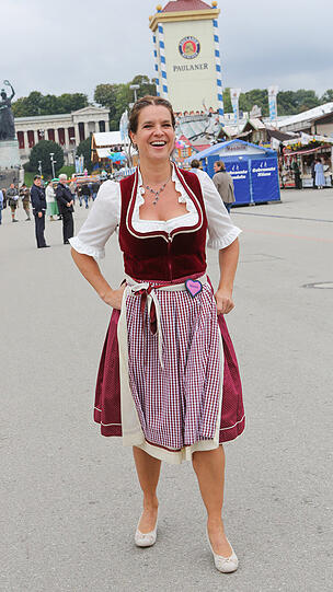 DA SIND ALLE-SAMT BEGEISTERT: Kati Witts Samt-Dirndl ist wie die Trägerin: fröhlich, herzlich. Kein Doppelter Rittberger, aber ein Toeloop.