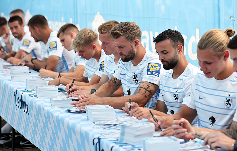 Die Löwen-Spieler fleißig beim Signieren der Autogrammkarten.