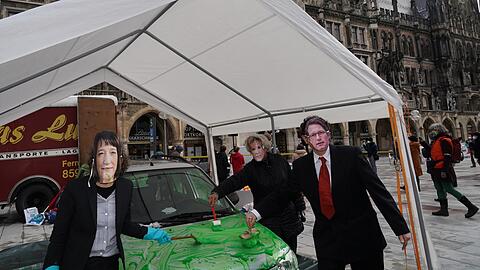 Protest am Rathaus: Verkleidete Aktivisten bemalen ein Auto mit grüner Farbe, um auf sogenanntes "Greenwashing" (Vorgeben, umweltfreundlich zu sein, ohne das zu erfüllen" aufmerksam zu machen.