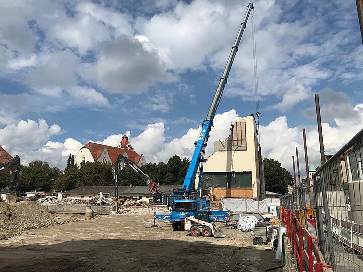 Hier schiebt dieser Kranarm die Staub-Schutzwand vors Gebäude.