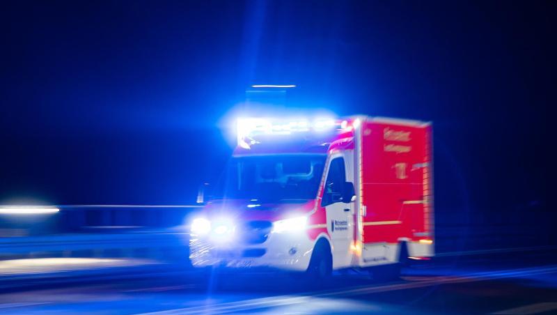 Ein Rettungswagen der Feuerwehr fährt mit Blaulicht durch eine Straße.