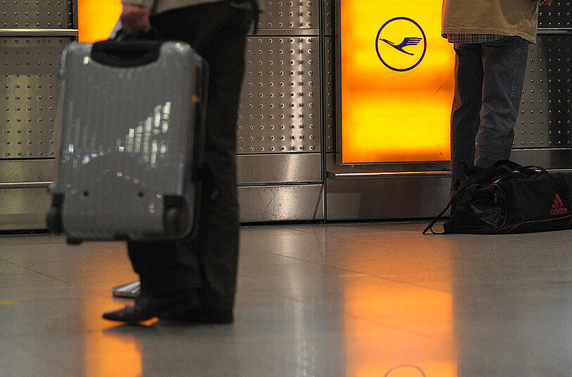 Reisende stehen im Flughafen Düsseldorf an der Gepäckabgabe der Lufthansa.
