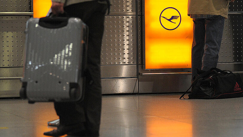 Reisende stehen im Flughafen Düsseldorf an der Gepäckabgabe der Lufthansa.