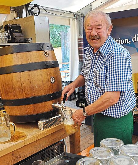 Peter Hauer zapft auf der Bartlmädult eine Maß Bier aus dem Fass