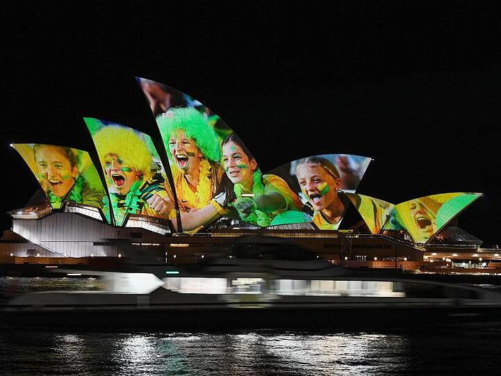 Australien und Neuseeland sind die Gastgeber der Frauenfußball-Weltmeisterschaft 2023: Das Opernhaus wird mit leuchtenden bunten Fotos von Fußball-Fans angestrahlt.