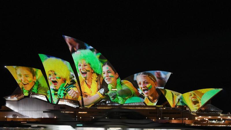Australien und Neuseeland sind die Gastgeber der Frauenfußball-Weltmeisterschaft 2023: Das Opernhaus wird mit leuchtenden bunten Fotos von Fußball-Fans angestrahlt. Australien und Neuseeland sind die Gastgeber der Frauenfußball-Weltmeisterschaft 2023: Das Opernhaus wird mit leuchtenden bunten Fotos von Fußball-Fans angestrahlt.