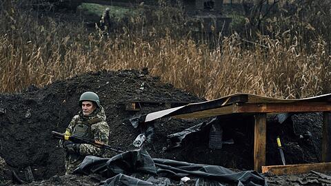 Ein ukrainischer Soldat steht in einem Stellungsgraben in Bachmut.