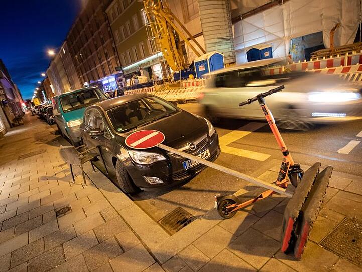 Ein vom Wind umgestürztes Verkehrszeichen liegt auf der Motorhaube eins PKW.