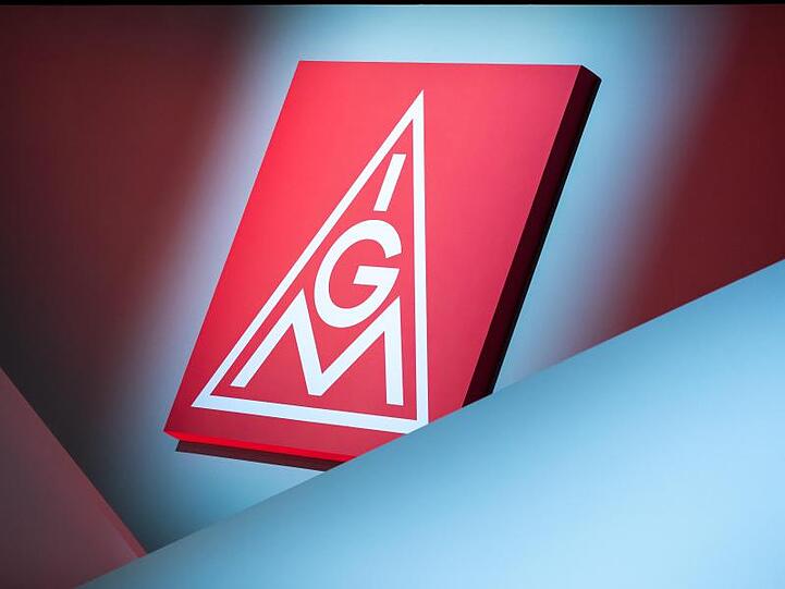 Das Logo der IG Metall hängt über einer Bühne. Foto: Daniel Karmann/dpa/Archivbild