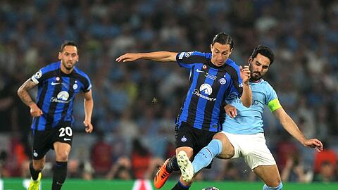 Der deutsche Nationalspieler Ilkay Gündogan (r) attackiert Inter Matteo Darmian.