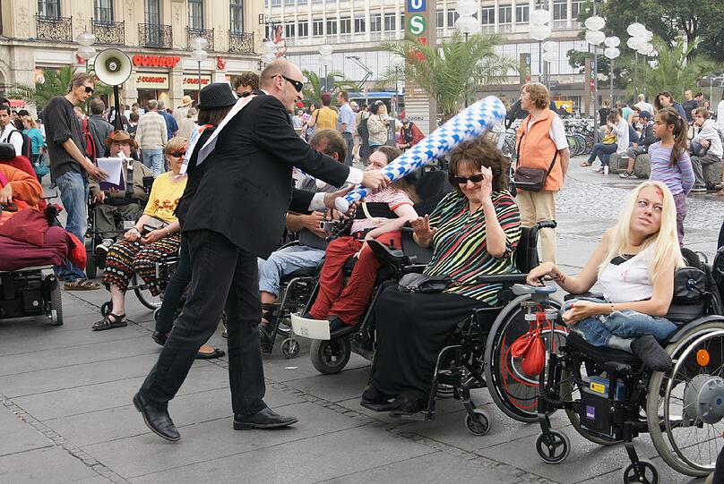 Eine bizarre Aktion: das "Krüppelschlagen", das auf die Benachteiligung behinderter Menschen aufmerksam machen soll.