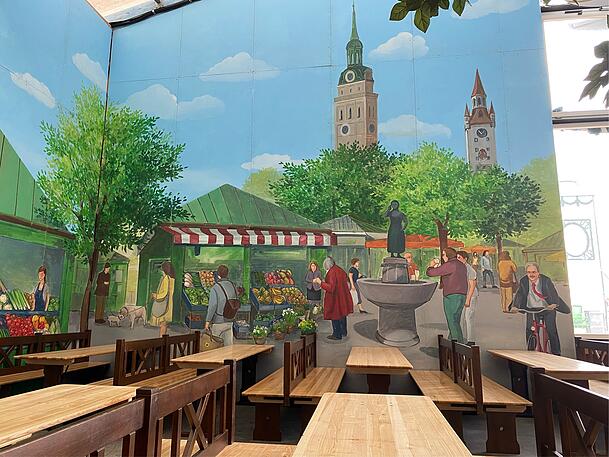Das Hackerzelt ist innen rundum mit Szenen aus München bemalt. Wer radelt da rechts unten ins Bild? Unverkennbar: Christian Ude – aber wieso eigentlich?