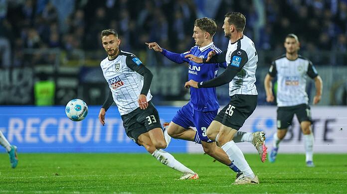 Philipp Maier (l.), damals noch im Trikot des SSV Ulm, und sein Teamkollege Felix Higl (r.) bedrängen Schalkes Max Grüger.