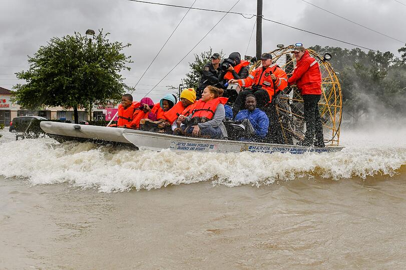 Helfer evakuieren in Houston Bewohner mit Hilfe eines Bootes. Im Südosten von Texas herrscht der Ausnahmezustand.