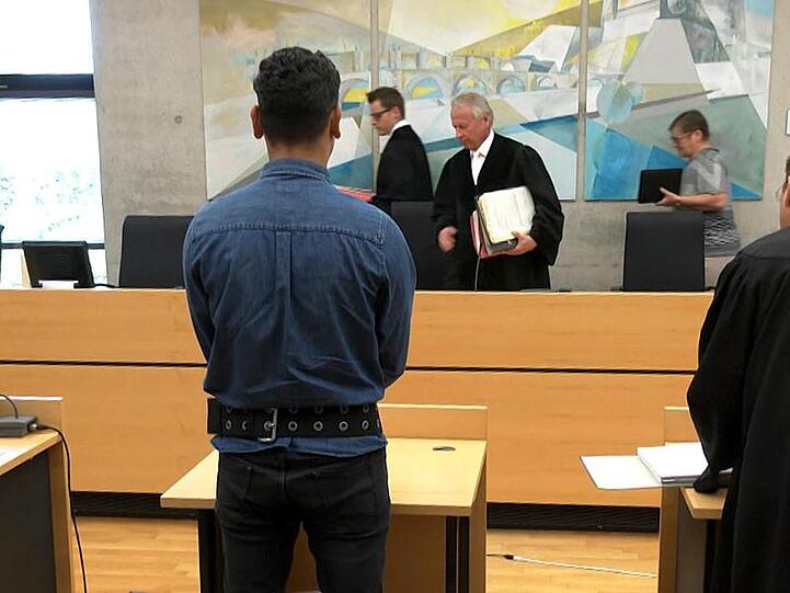 Der Angeklagte (M) steht im Sitzungssaal im Landgericht. Foto: Frm/dpa/Archivbild