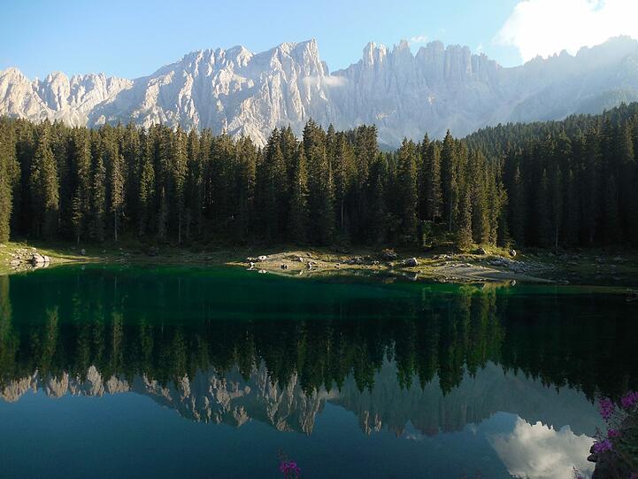 Die Nordwand des Latemar spiegelt sich im türkisblauen Karersee.