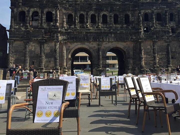 Leere Stühle vor der Porta Nigra in Trier.