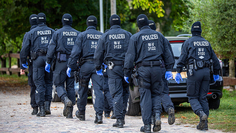 Einsatzkräfte der Polizei führen auf einem polizeibekannten Grundstück eine Durchsuchungsaktion durch. (Archivbild)