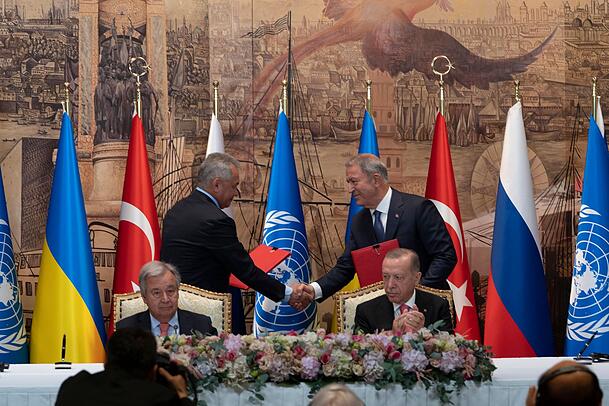 Antonio Guterres (vorn l), UN-Generalsekretär, und Recep Tayyip Erdogan (r), Präsident der Türkei, sitzen während einer Unterzeichnungszeremonie im Dolmabahce-Palast, während sich zwei Vertreter der Delegationen der Ukraine und Russlands die Hände reichen. Antonio Guterres (vorn l), UN-Generalsekretär, und Recep Tayyip Erdogan (r), Präsident der Türkei, sitzen während einer Unterzeichnungszeremonie im Dolmabahce-Palast, während sich zwei Vertreter der Delegationen der Ukraine und Russlands die Hände reichen.