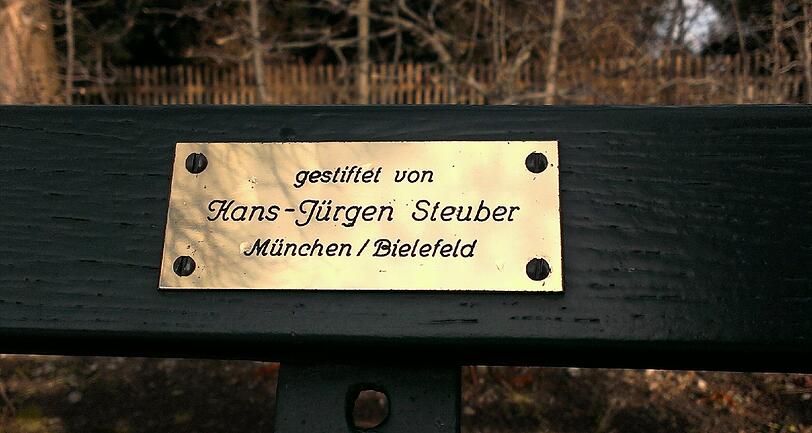 Im Englischen Garten und Nymphenburger Schlosspark haben Münchner tausende Plaketten mit Widmungen auf Parkbänken angebracht.