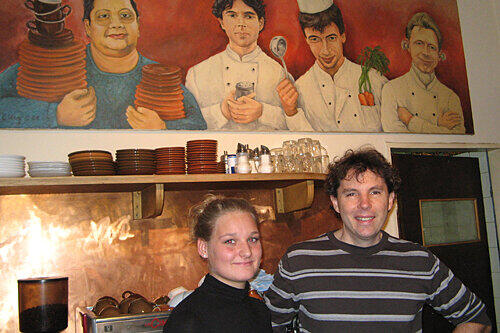 Im fränkischen Lönneberga hängen die drei Betreiber immer an der Wand: Kellnerin Nadja und Service-Chef Werner Krögel posieren vor dem Gemälde, das Cornelia Krug zur Eröffnung schenkte.