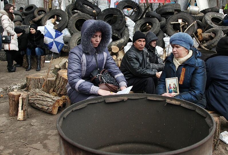 Pro-Russische Aktivisten sitzen bei einer Barrikade vor einer regionalen Polizeistelle in Slavansk, Ukraine.
