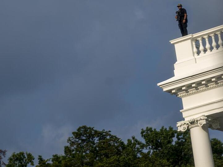 Ein Mitglied des Secret Service steht zur Sicherung auf dem Dach des Weißen Hauses.