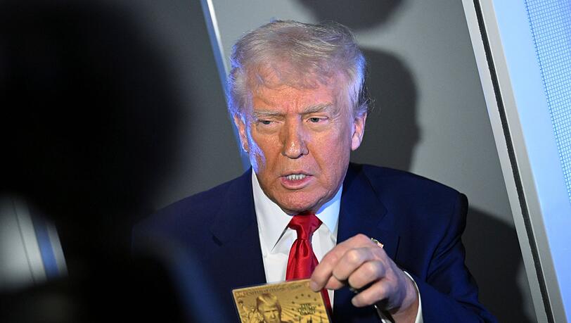 US-Präsident Donald Trump zeigt eine sogenannte Gold Card, auf der er abgebildet ist.