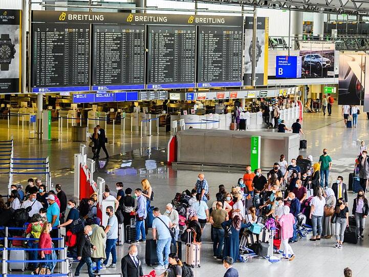 Reisende stehen in der Abflughalle im Terminal 1 am Flughafen Frankfurt. Hier herrscht noch immer deutlich weniger Betrieb als in Vor-Corona-Zeiten.