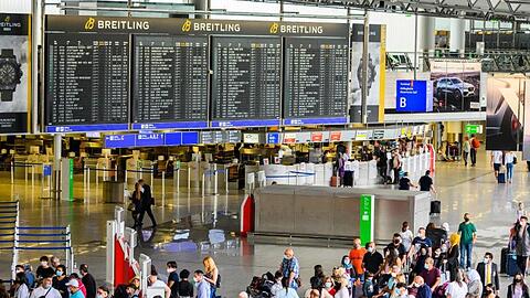 Reisende stehen in der Abflughalle im Terminal 1 am Flughafen Frankfurt. Hier herrscht noch immer deutlich weniger Betrieb als in Vor-Corona-Zeiten.