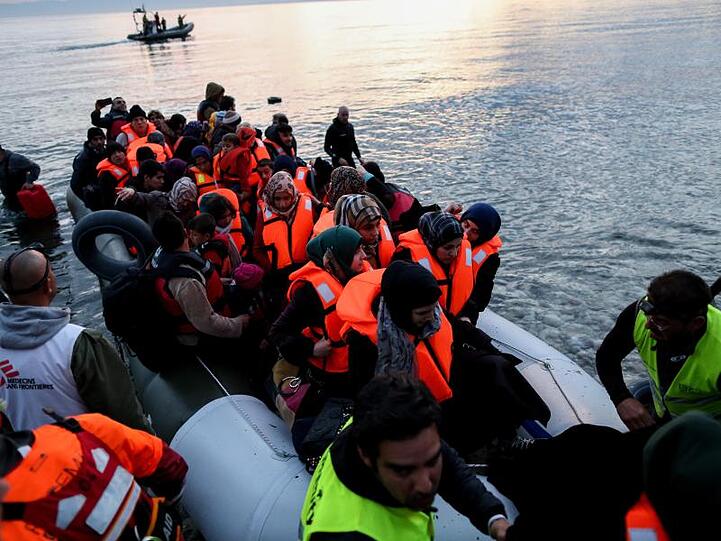 Freiwillige helfen auf der griechischen Insel Lesbos völlig erschöpften Flüchtlinge aus ihrem Boot.