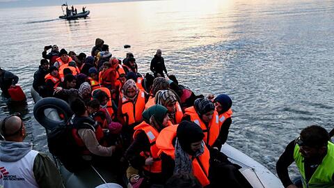Freiwillige helfen auf der griechischen Insel Lesbos völlig erschöpften Flüchtlinge aus ihrem Boot.