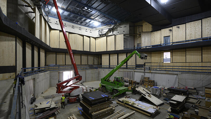 Das Innere der Interimsphilharmonie mit Blick auf das Podium: Die massiven hellen Holzplatten erhalten derzeit eine schwarze Verkleidung. Das Innere der Interimsphilharmonie mit Blick auf das Podium: Die massiven hellen Holzplatten erhalten derzeit eine schwarze Verkleidung.