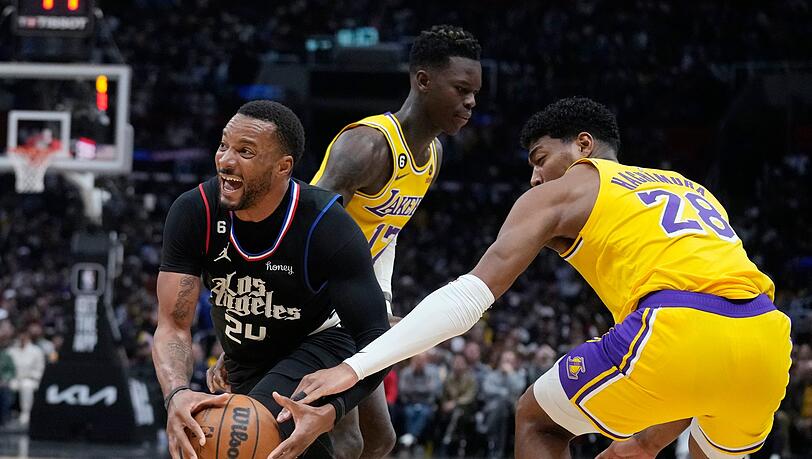 Clippers-Guard Norman Powell (l) geht an Dennis Schröder (M) und Rui Hachimura (28) von den Los Angeles Lakers vorbei.