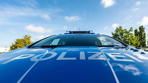 Auf der Motorhaube eines Streifenwagens steht der Schriftzug "Polizei".