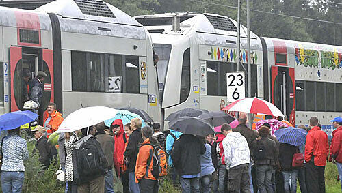 Raus in den Regen: Die Fahrgäste verlassen den Zug Raus in den Regen: Die Fahrgäste verlassen den Zug