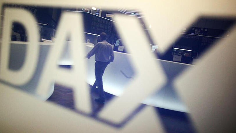 Ein Händler geht über das Parkett in der Börse in Frankfurt am Main und spiegelt sich dabei in einem Logo des Deutschen Aktienindexes (DAX). Ein Händler geht über das Parkett in der Börse in Frankfurt am Main und spiegelt sich dabei in einem Logo des Deutschen Aktienindexes (DAX).