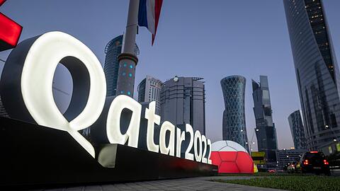 Das Logo der WM in Katar steht vor dem Doha Exhibition and Convention Center, in dem die Auslosung stattfindet.