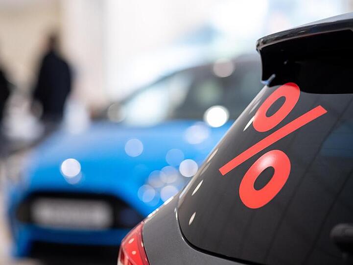 Ein Prozentzeichen klebt auf der Scheibe eines Autos in einem Autohaus in Stuttgart (Archiv).