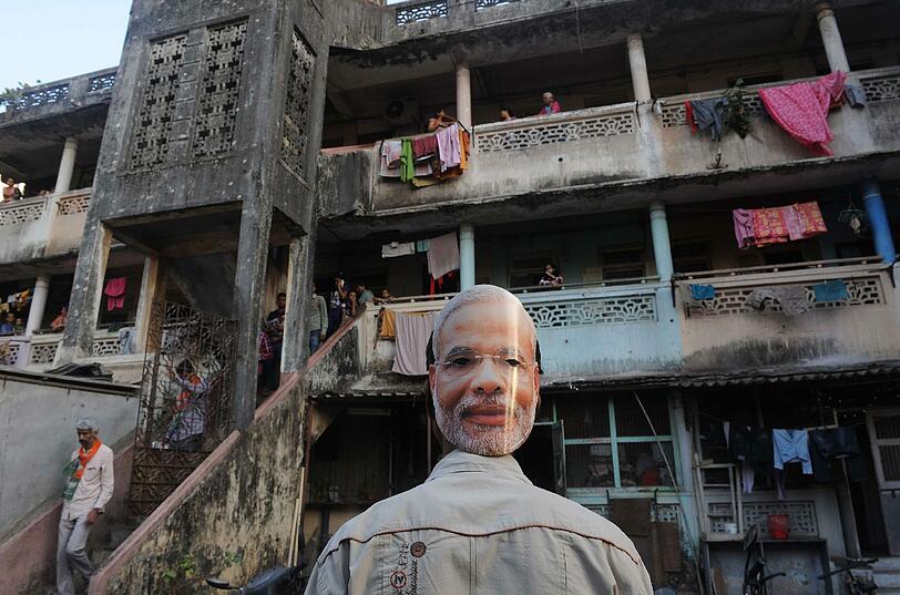 Ein Unterstützer trägt eine Maske des Kandidaten der Indischen Bhatiya Janta Partei (BJP) für das Amt des Premierministers Narendra Modi. In Indien begannen die mehrphasigen Wahlen am 7. April. Es sind die größten Wahlen der Welt.
