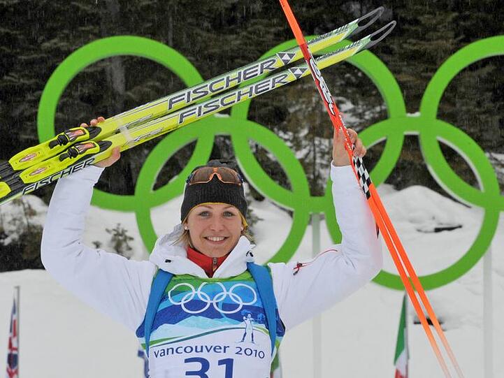 Magdalena Neuner feiert vor den Olympischen Ringen in Whistler ihre Silbermedaille.