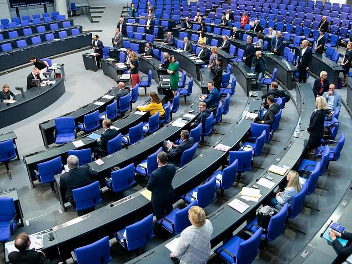 Abgeordnete stehen im Bundestag. Foto: Bernd von Jutrczenka/dpa/Archivbild