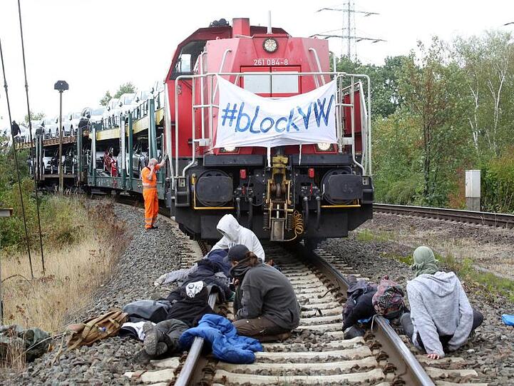 Umweltschutzaktivisten haben sich bei einer Blockade auf einem Gleis vor einem Zug mit Neufahrzeugen angekettet.