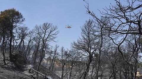 Ein Hubschrauber fliegt über das brennende Gebiet in der Nähe des griechischen Dorfes Ziria.