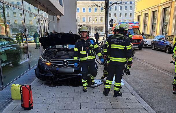 Feuerwehrmänner an der Unfallstelle vor dem demolierten Mercedes. Feuerwehrmänner an der Unfallstelle vor dem demolierten Mercedes.