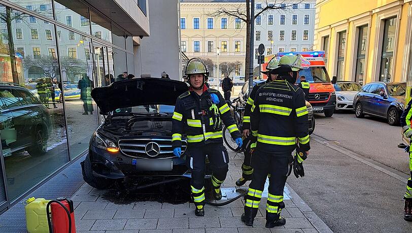 Feuerwehrmänner an der Unfallstelle vor dem demolierten Mercedes. Feuerwehrmänner an der Unfallstelle vor dem demolierten Mercedes.
